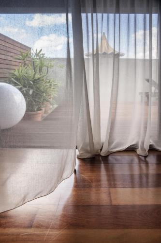 a room with a window with white curtains at The Ranee Boutique Suites in Kuching