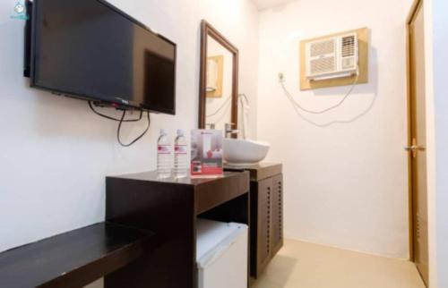 un soggiorno con TV e tavolo con armadietto di Taj Guesthouse Boracay a Boracay