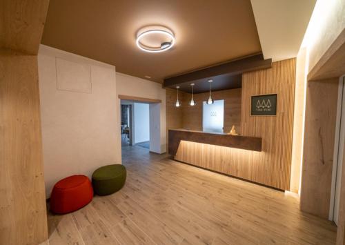Habitación grande con suelo de madera y sala de espera. en Hotel Tre Pini, en Danta