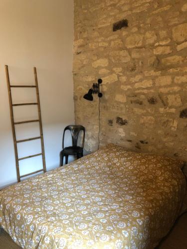 Loft de charme centre de Montcuq في Montcuq: غرفة نوم بسرير وجدار حجري