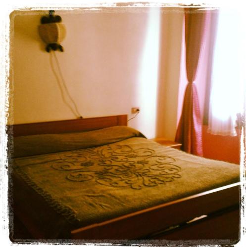 a bedroom with a bed with a green blanket and a window at Paradiso vista inferno in Tresivio