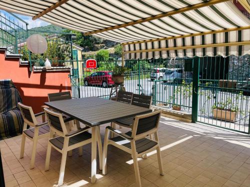 a wooden table and chairs on a patio at Beds house, pace e tranquillità a 5 min dal mare.. in Avegno