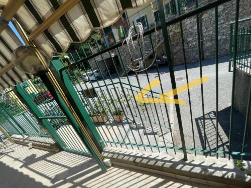 a fence with yellow arrows on it next to a street at Beds house, pace e tranquillità a 5 min dal mare.. in Avegno
