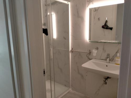 y baño con ducha, lavabo y espejo. en Nic House, en Venecia