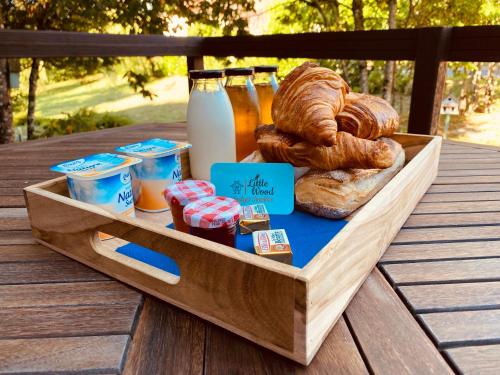 Una bandeja de madera con pan y pasteles sobre una mesa. en Little Wood Lodges, en Bailly-aux-Forges