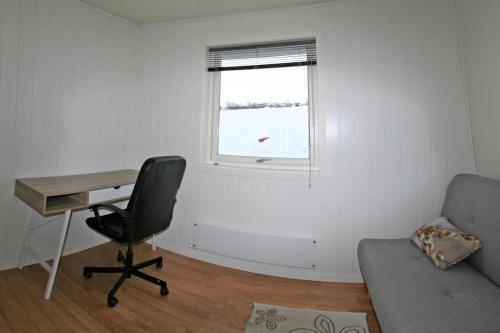 a room with a desk and a chair and a window at Nesseby Guesthouse in Varangerbotn