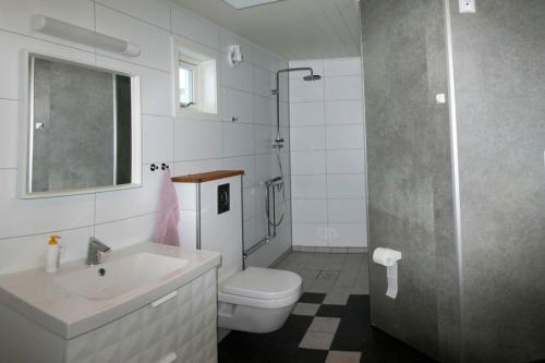 ein weißes Bad mit einem Waschbecken und einem WC in der Unterkunft Nesseby Guesthouse in Varangerbotn