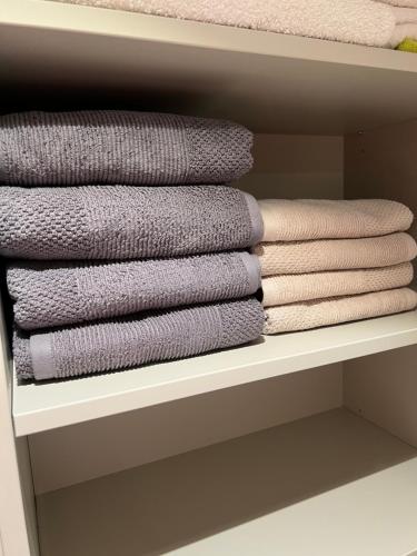 a group of folded towels on a shelf at Biliūno apartamentai prie jūros in Palanga