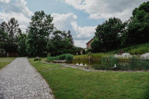 a garden with a stone path and a pond at Penzion U Skutilů in Pilníkov