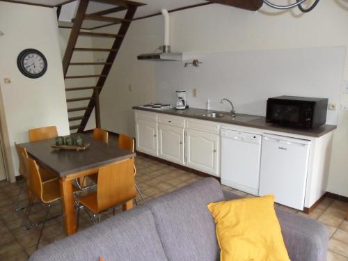 a living room with a couch and a table and a kitchen at Schophemmerhoeve in Voeren