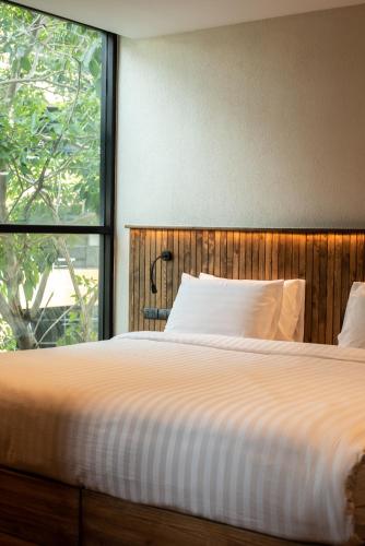 a bedroom with a large bed with a large window at karaarom hotel in Bangkok