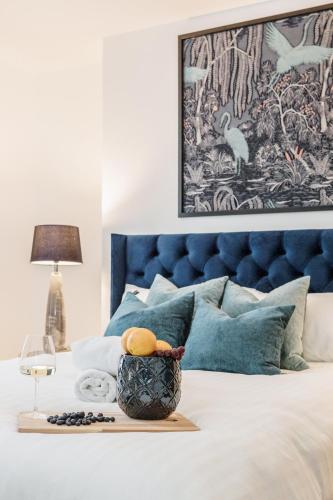 a bedroom with a bed with a blue headboard at Elegant 3Bed Apartment in Kensington Olympia in London