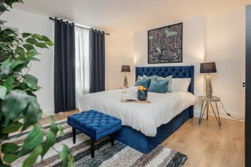 a bedroom with a blue bed and a blue chair at Elegant 3Bed Apartment in Kensington Olympia in London