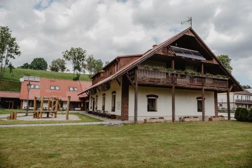 an old house with a gambrel roof and a playground at Penzion U Skutilů in Pilníkov