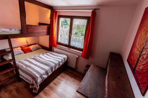 sypialnia z łóżkiem piętrowym i oknem w obiekcie Bike Bistro a penzion U Všech andělů w mieście Nové Město pod Smrkem