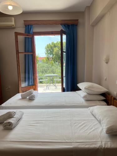 ミティムナにあるMolyvos Stars Apartmentsの窓付きの客室で、ベッド2台を利用できます。