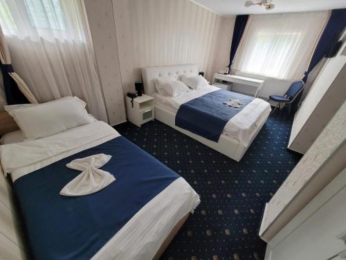 a hotel room with two beds with towels on them at Hotel Green Palace in Sinaia