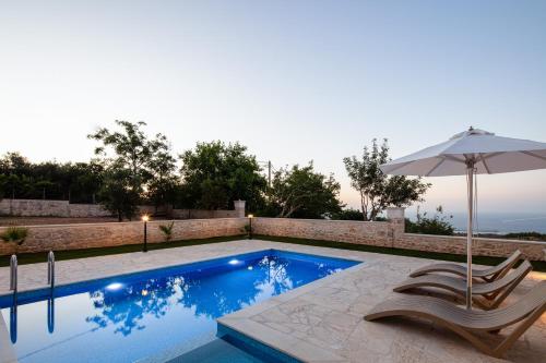 a swimming pool with two chairs and an umbrella at Karma House in Tria Monastiria