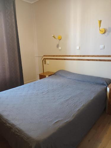 sypialnia z łóżkiem z niebieskim kocem w obiekcie Hôtel de Lorraine w Paryżu