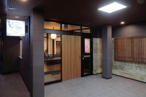 a bathroom with a large mirror and a walk in shower at Tabist Onsen Guest House Yukori Bandai-Atami in Koriyama