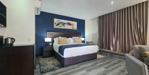 Habitación de hotel con cama y sofá en The Grand Aria Hotel and Conference Centre, en Gaborone