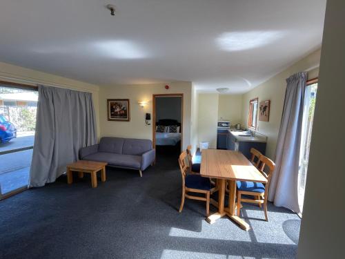 a living room with a table and a couch at Central Park Motor Lodge in Christchurch
