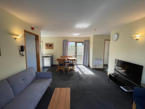 a living room with a couch and a table at Central Park Motor Lodge in Christchurch