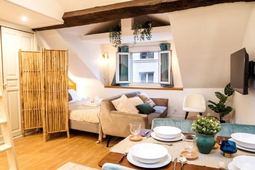 a living room with a couch and a table at Spacious studio in Paris Hyper Center - Smart TV & WIFI - 4P in Paris