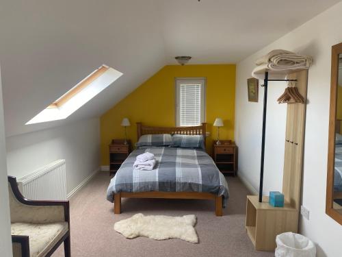 1 dormitorio con cama y pared amarilla en Barnweil, en Stein