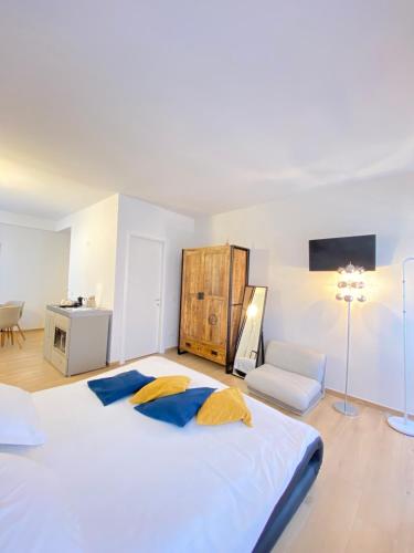 a bedroom with a large white bed and a chair at Isola Bella Studios in Stresa