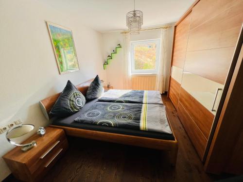 ein kleines Schlafzimmer mit einem Bett mit einem Kopfteil aus Holz in der Unterkunft Casparidyll in Sigmaringen