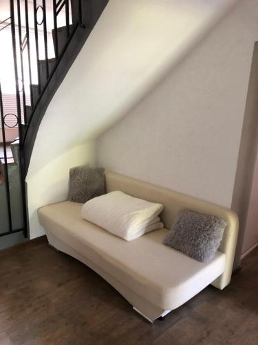 a couch with two pillows sitting under a staircase at Ferienwohnung in Dahn in Dahn