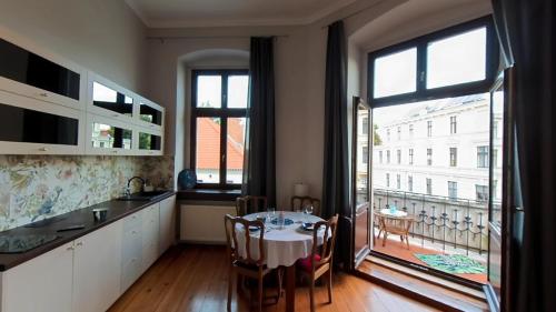 uma cozinha com uma mesa e uma grande janela em Astronomiczny apartament , mieszkanie 2 pokojowe. Parking. em Toruń