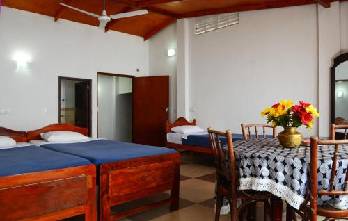 a bedroom with two beds and a table with flowers on it at Ella Gap Panorama in Ella