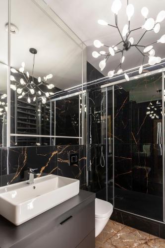 a bathroom with a white sink and a mirror at Apartamenty Przy Plaży Klif in Gdynia