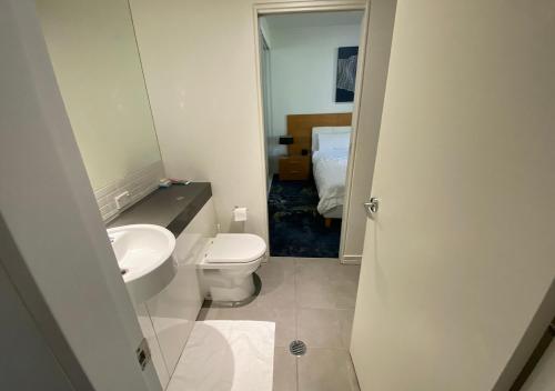a bathroom with a white toilet and a sink at Lovely One Bedroom Apartment "Cairns Harbour Lights" in Cairns
