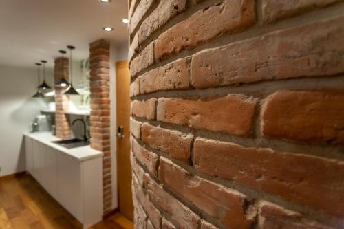 a brick wall in a room with a white counter at Apartamenty Przy Plaży Klif in Gdynia