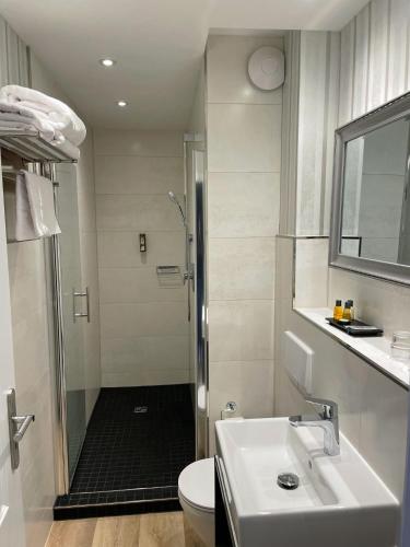 a bathroom with a shower and a sink and a toilet at Fisher's Inn in Zingst