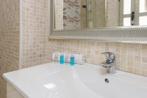 lavabo blanco en el baño con espejo en WintoWinRentals Genial Apartamento, Céntrico y Silencioso, en Málaga