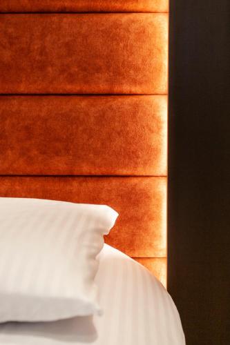 a white pillow sitting on a bed next to a headboard at Apartamenty Przy Plaży Klif in Gdynia
