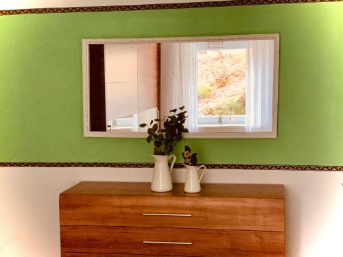 a green room with a mirror and a wooden dresser at Casparidyll in Sigmaringen