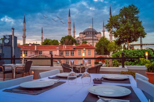 a table on a balcony with a view of the blue mosque at Sarnic Premier Hotel in Istanbul