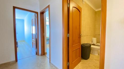 a bathroom with a door leading to a toilet at Apartamento Sol do Amanhã in Santa Cruz