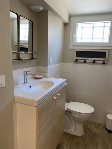 une salle de bain avec un lavabo et des toilettes dans l'établissement Aux Bains des Mots, à Saint-Aubin-sur-Mer