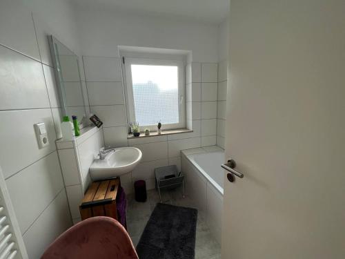 a bathroom with a sink and a bath tub and a window at Suite 110qm nahe Rhein in Krefeld