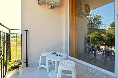 a small white table and chairs on a balcony at Di Mare Holiday Apartments in Kranevo