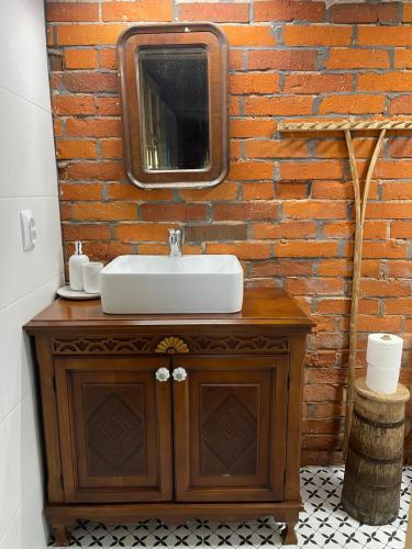 a bathroom with a sink and a mirror on a brick wall at INNA BAJKA in Nowy Berezów