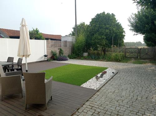 a patio with an umbrella and a lawn at Eira da Mila in Coimbra