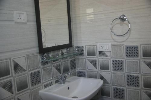 a bathroom with a sink and a mirror at Chandan Guest House in Leh