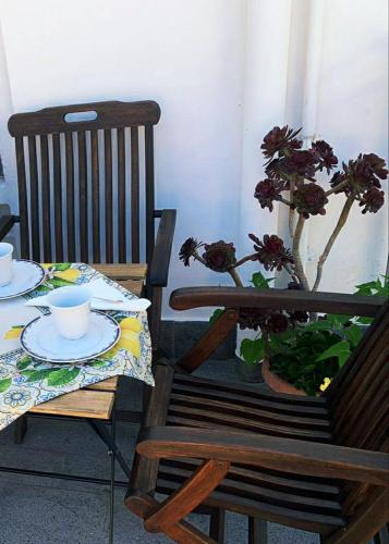 a table and a chair with a table and a plant at L'albero della vita in Minori